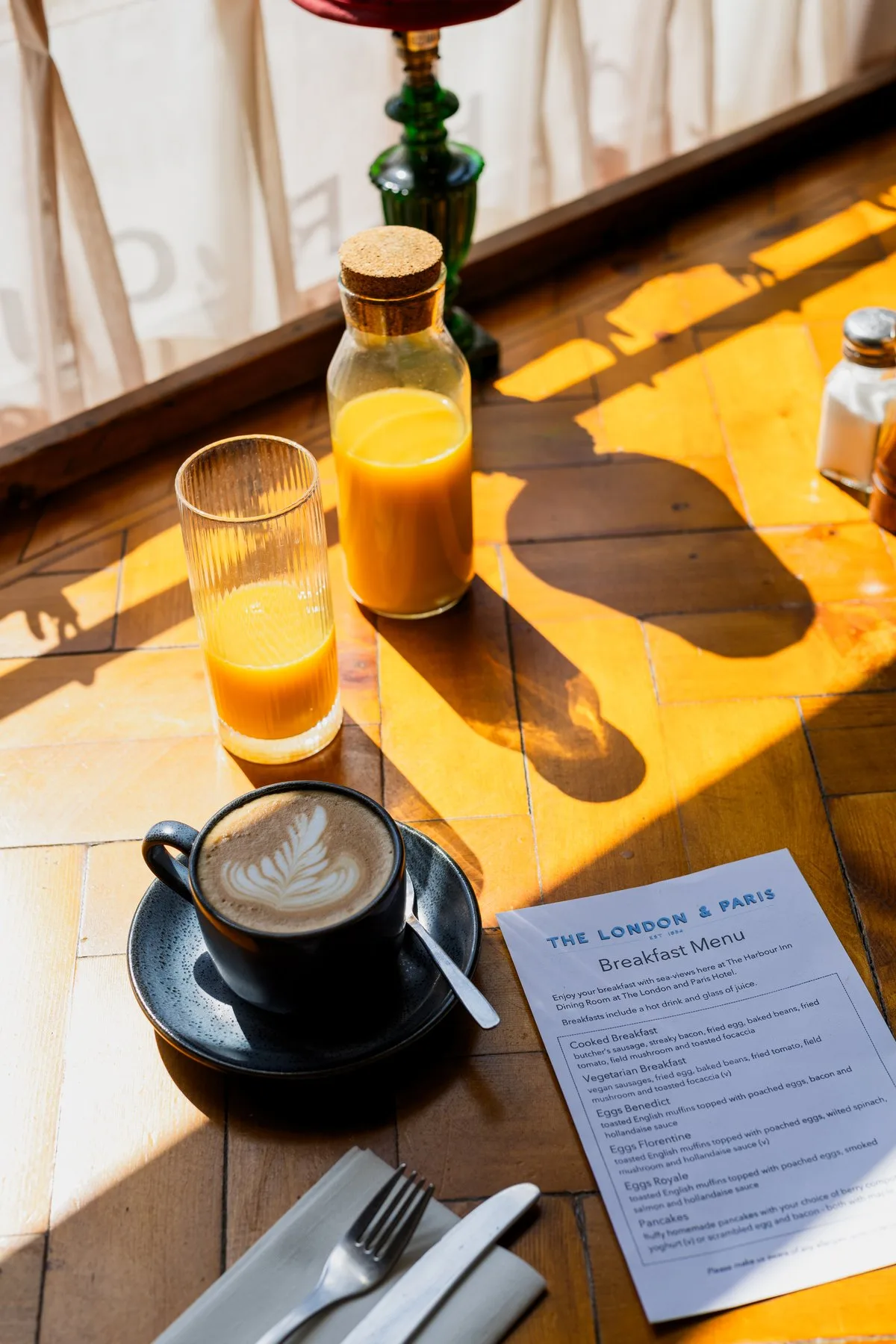 Coffee, orange juice and the breakfast menu on a table in London & Paris Hotel’s breakfast room