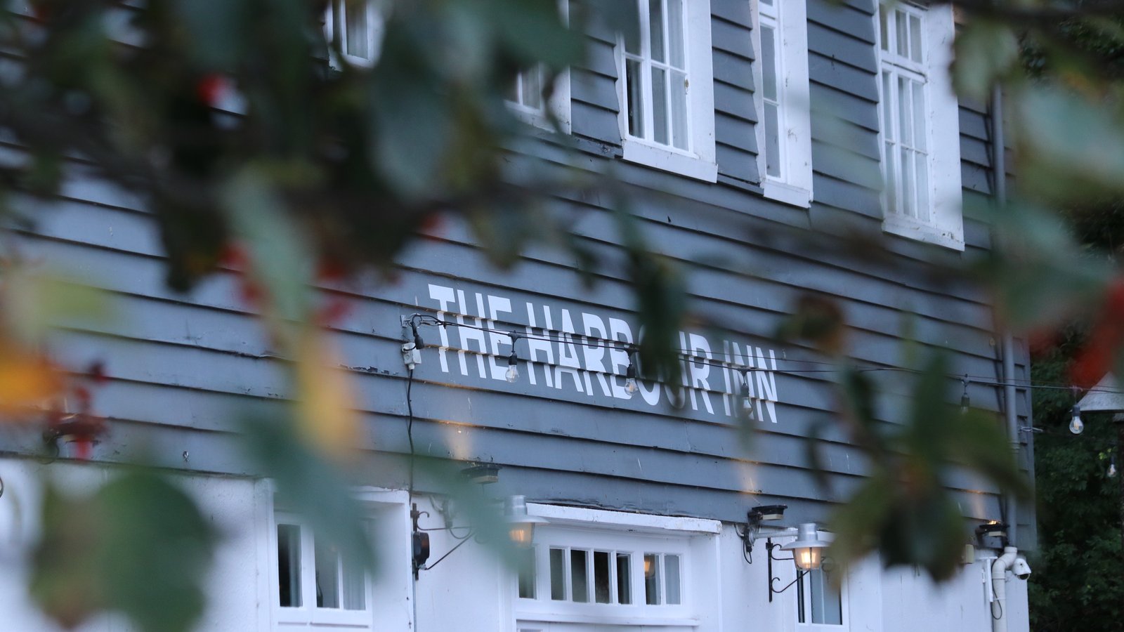 Harbour Inn's white weatherboarded frontage with its name painted proudly across the front