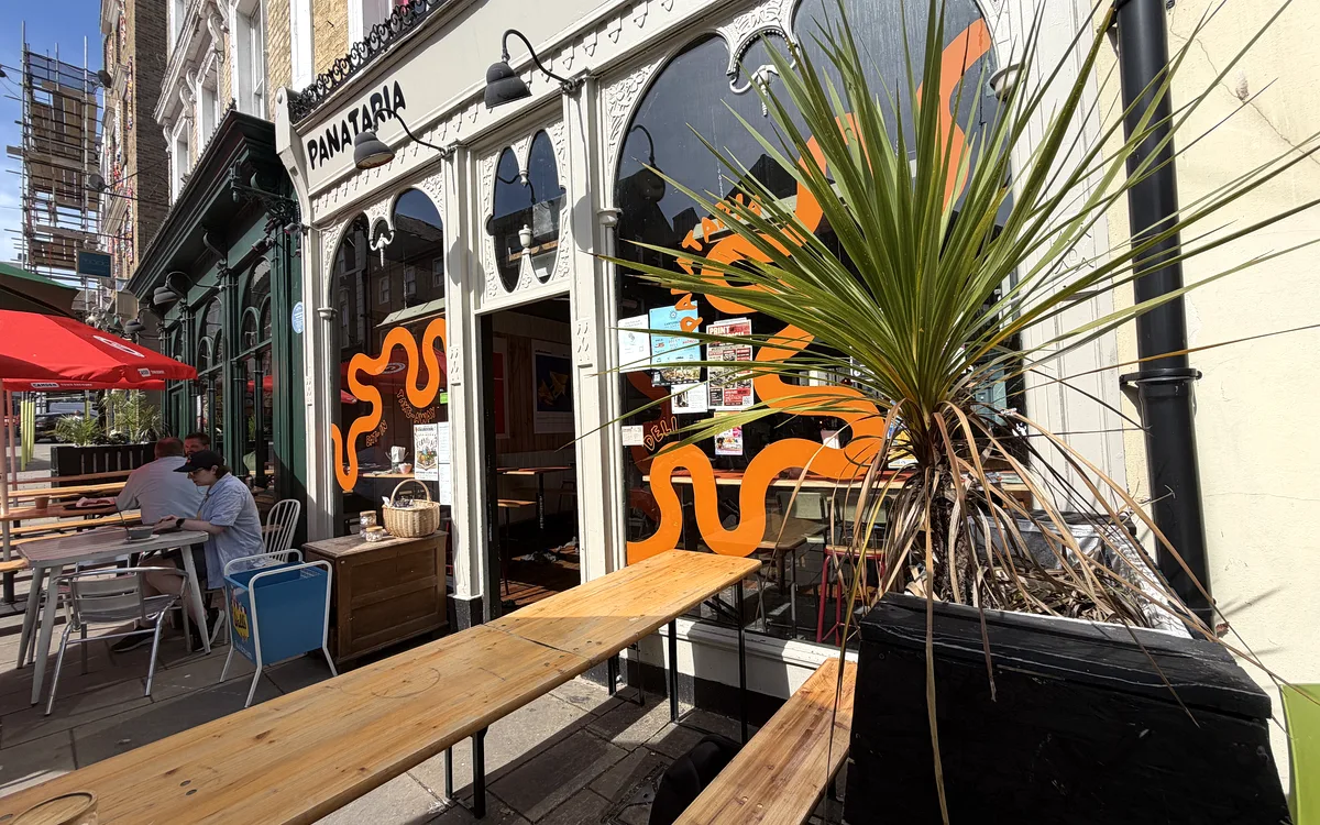 Panataria's terrace with benches and orange-wave signage
