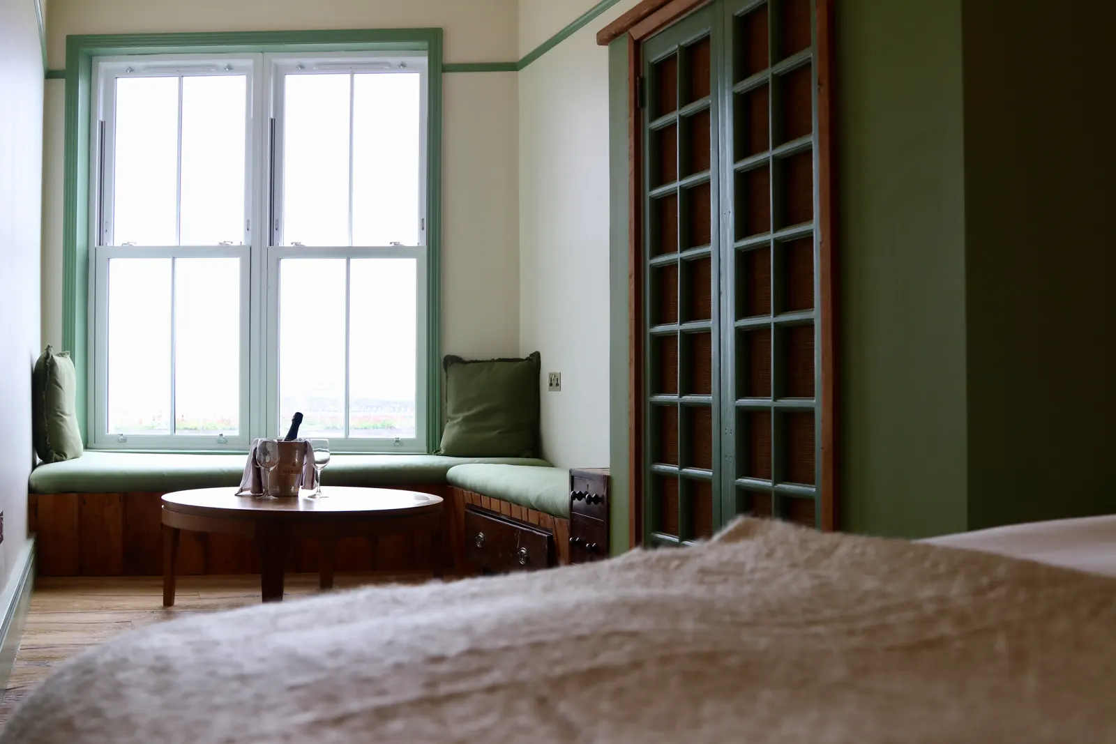 A bedroom with a bay window over the harbour