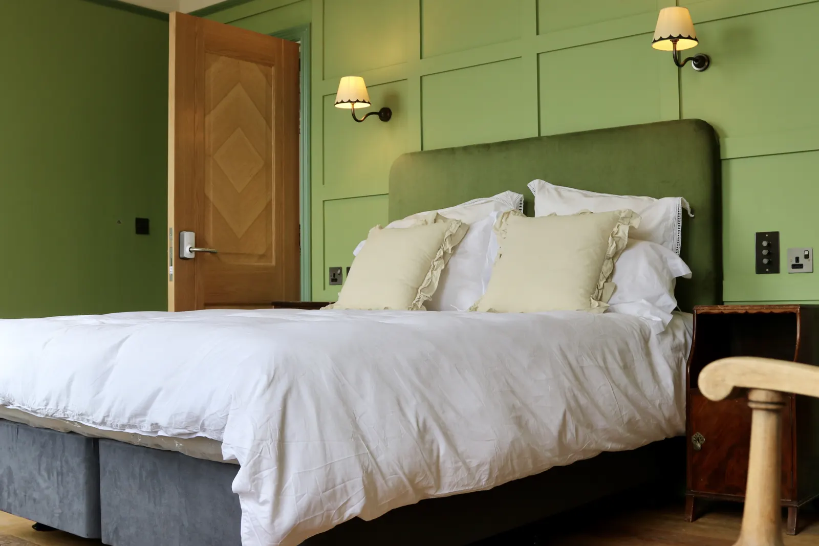 A bedroom with a green headboard