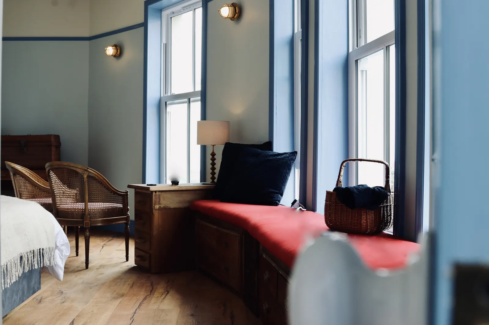 A bedroom with a window seat and an armchair