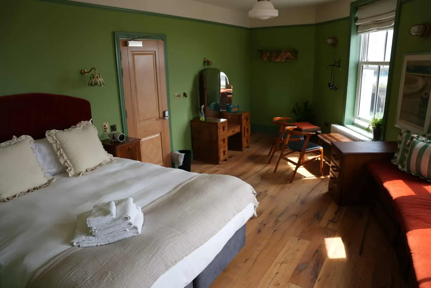 Room 1: green walls, a wooden floor and a dressing table