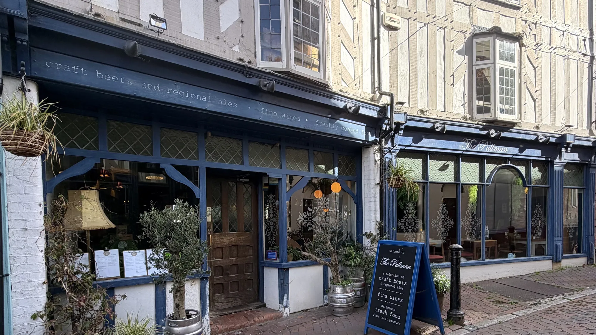 The Pullman’s navy-blue front on Church Street, with its sign over the windows, olive trees in barrels and a chalkboard by the door