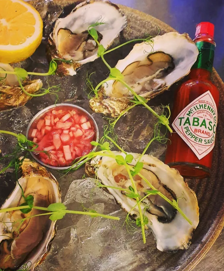 Fresh oysters on ice with lemon, shallot vinegar and Tabasco