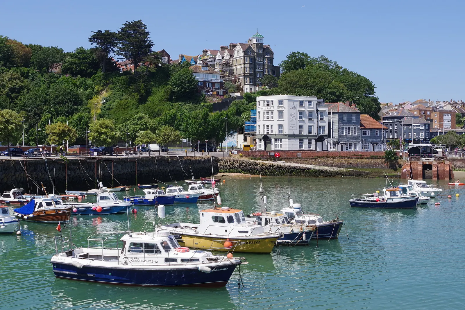 Boats in Folkestone harbour with London & Paris Hotel on the waterfront behind