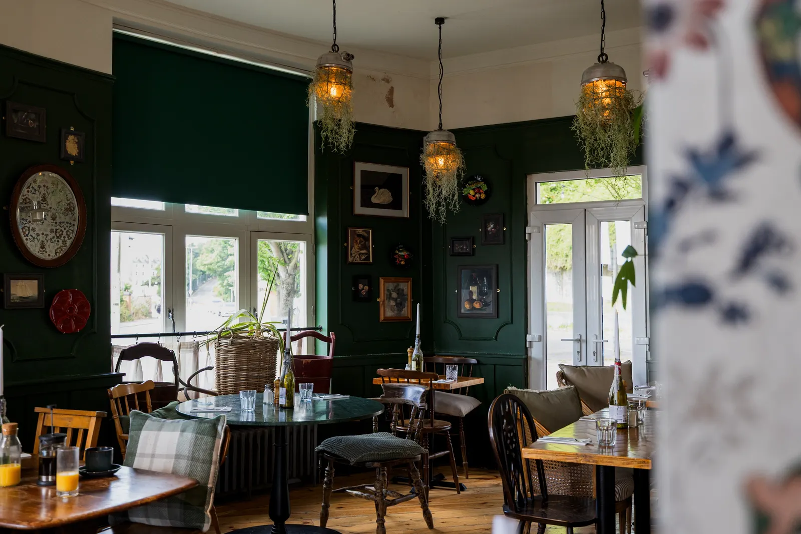 The green-panelled bar and breakfast room at London & Paris Hotel, Folkestone, with hanging lanterns