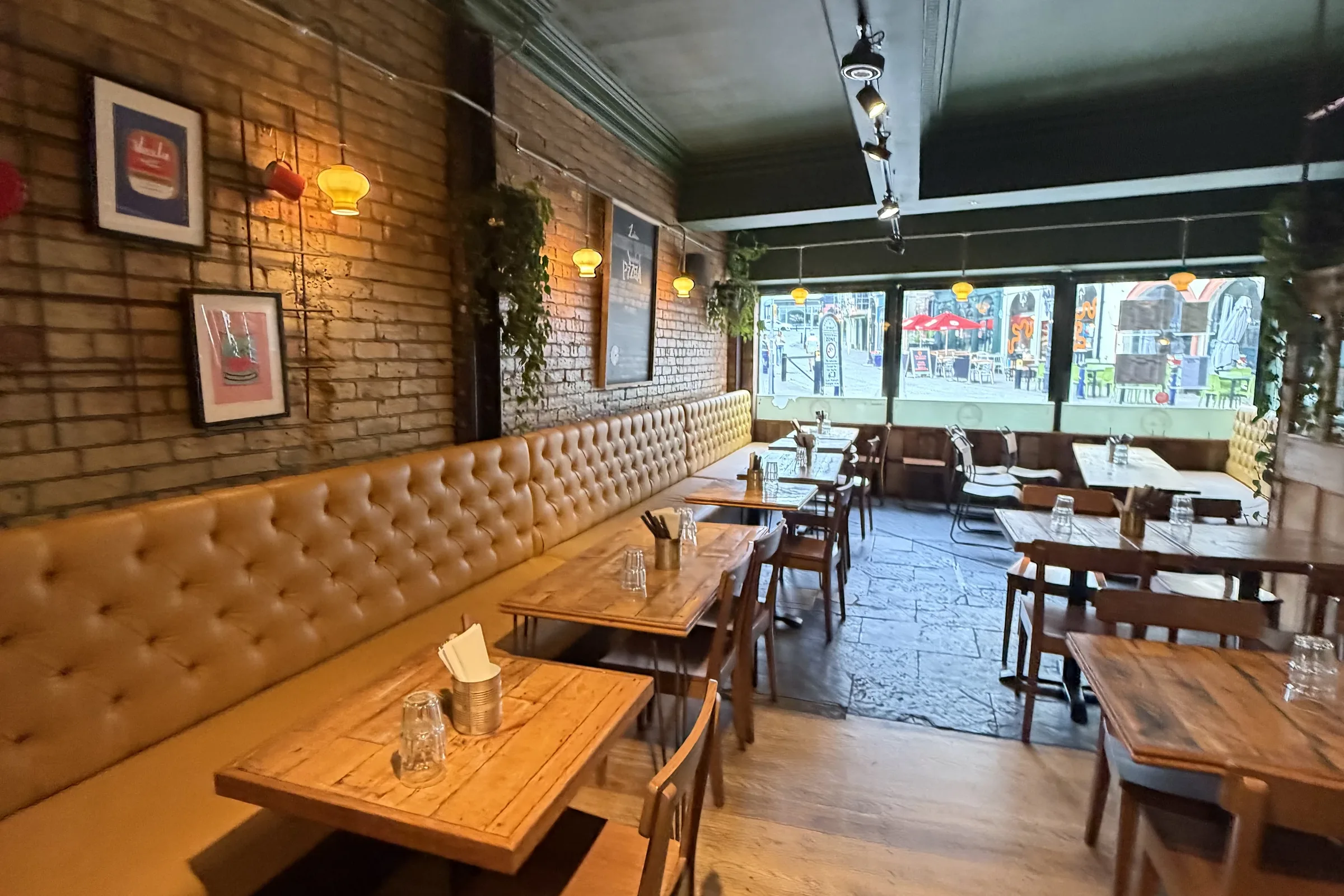 A long tan leather banquette and brick wall at Luben pizzeria, Folkestone