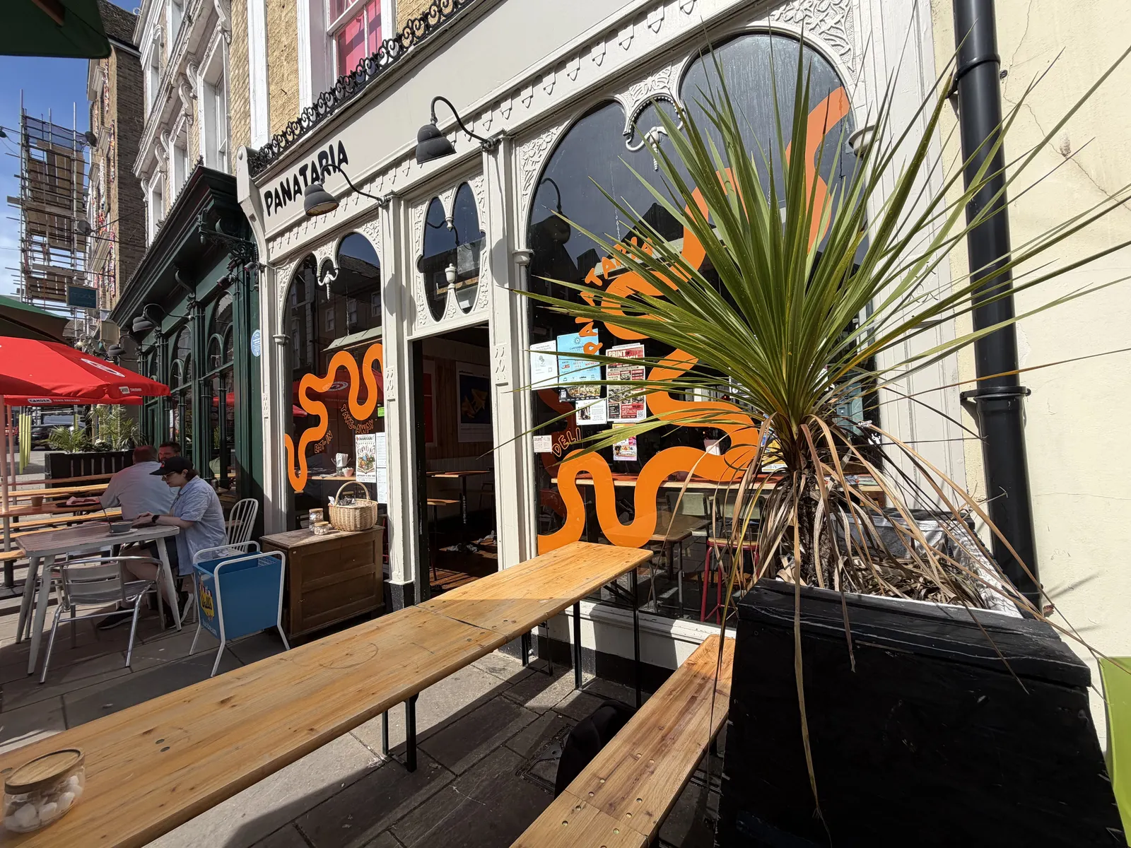 Panataria's outdoor bench seating under the orange swirl shopfront on Rendezvous Street, Folkestone