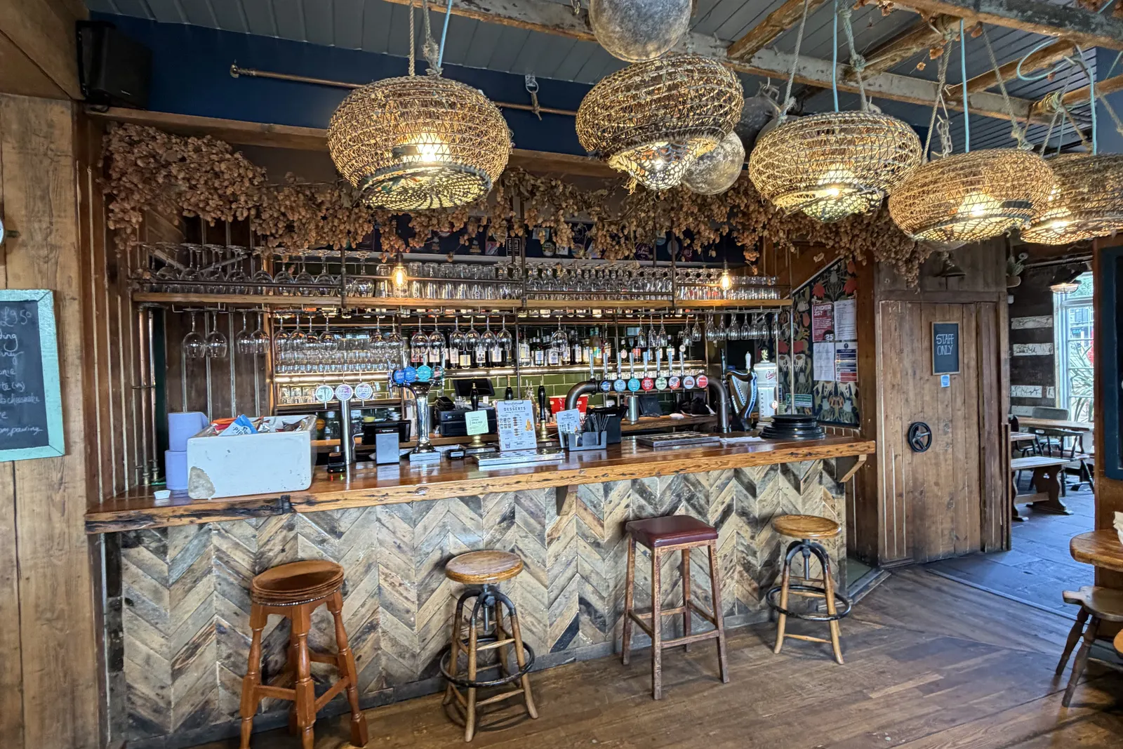 The bar room at Harbour Inn on Folkestone harbour, with wicker lamps and wood panelling