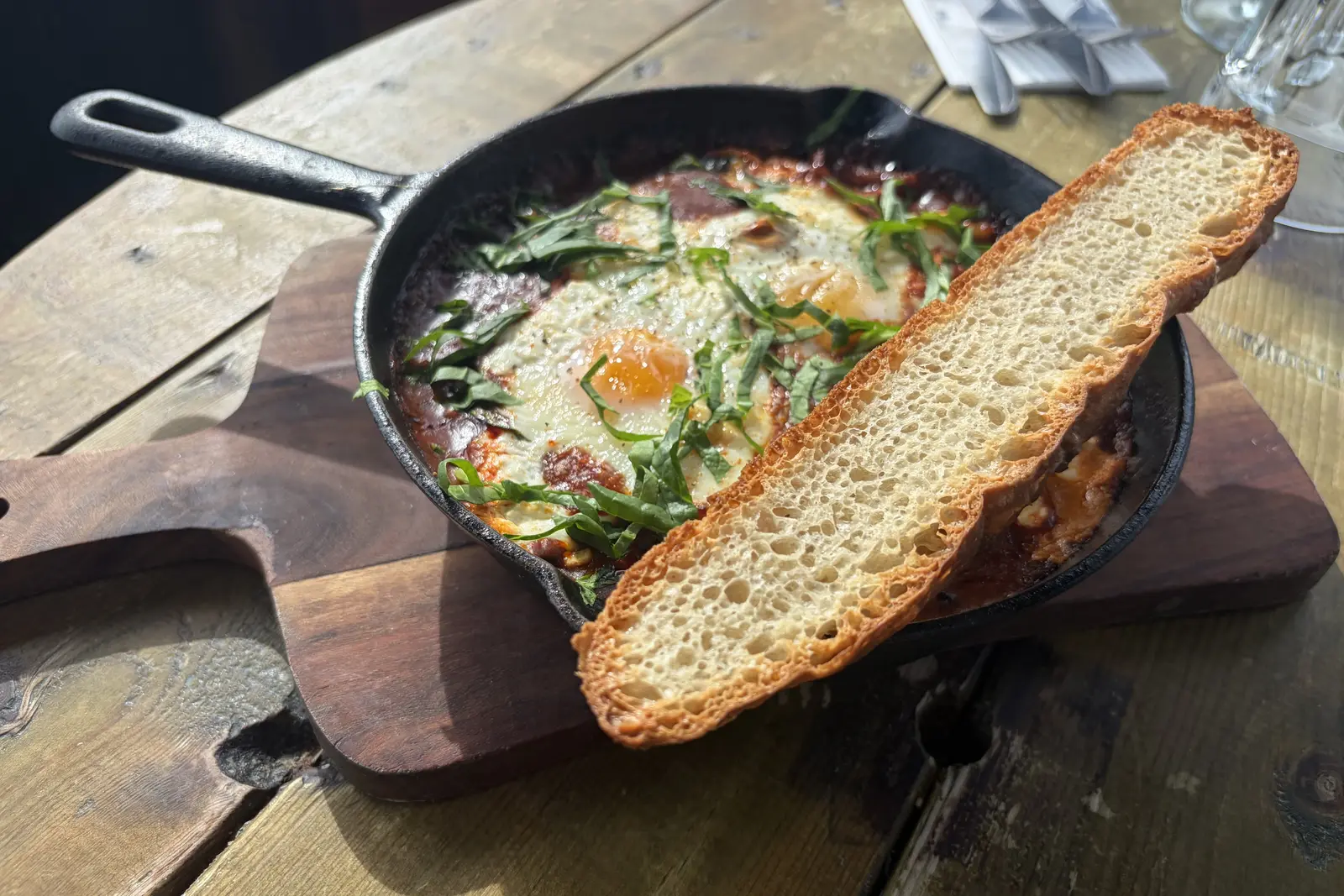 Baked eggs in tomato sauce in a skillet with sourdough at The Ship Inn, Sandgate
